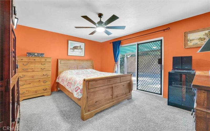 Master bedroom with ceiling fan and slider to patio.