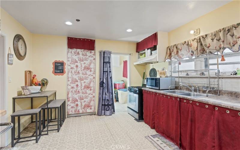 Kitchen with laundry room in the background