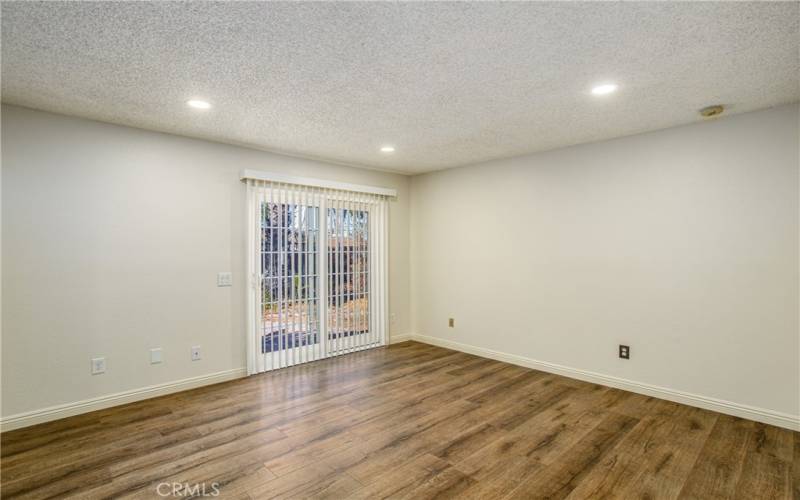 Primary bedroom with canned lighting and exit to the backyard