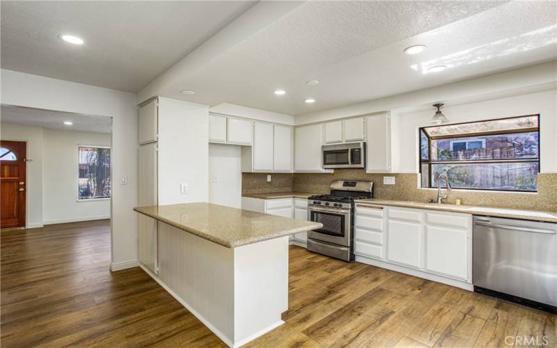 kitchen enjoys canned lighting and opens to family room.