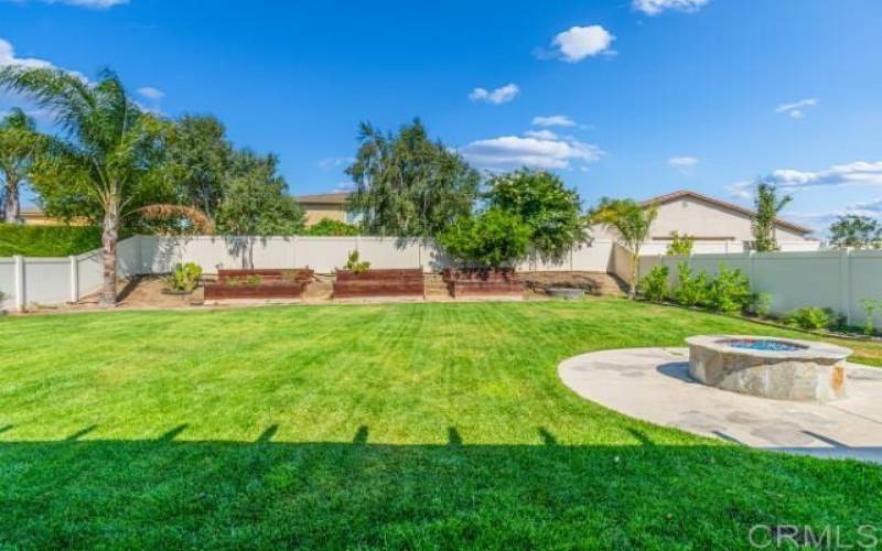 View of Backyard from the covered patio; notice the circular firepit