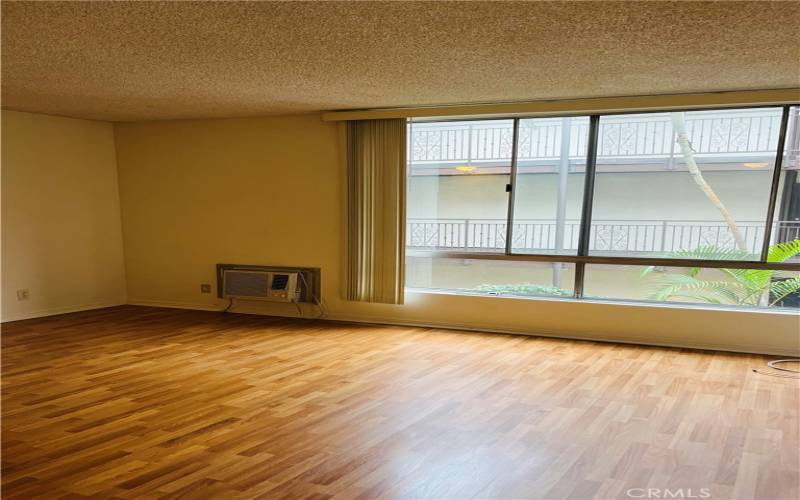 Bright, compact studio with honey-colored laminate floors.