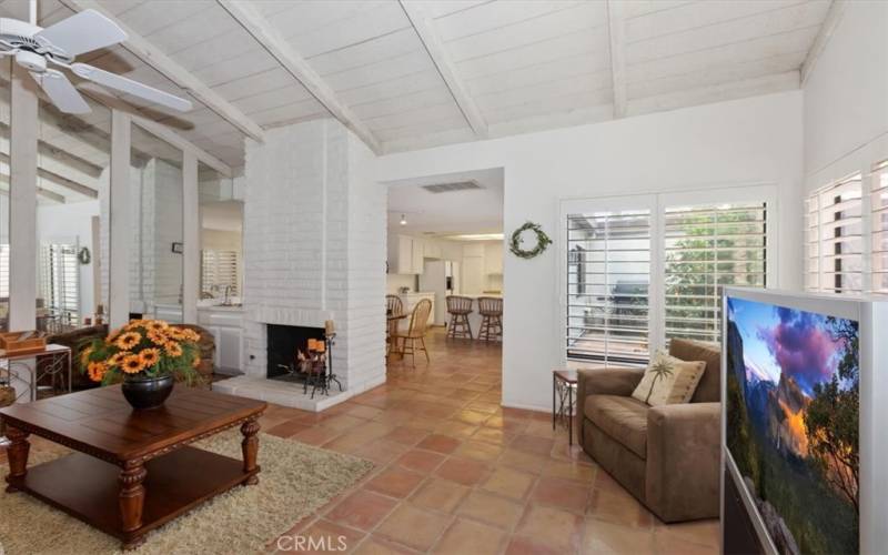 Living room with fireplace, wood beam ceiling and lots of light.