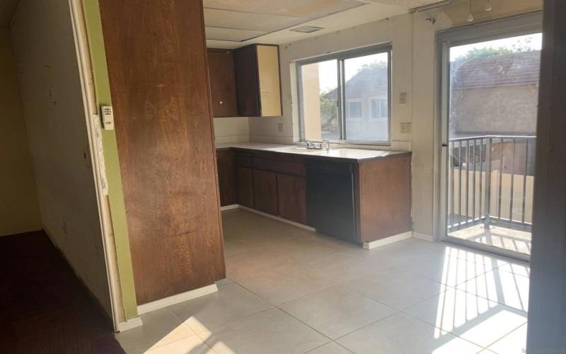 Kitchen has nook & sliidng doors to patio overlooking driveway