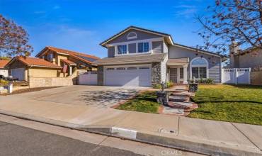 Front of House with wide driveway and gated RV parking.