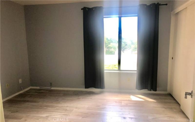 Spacious secondary bedroom with views of the trees, closet and brushed door hardware