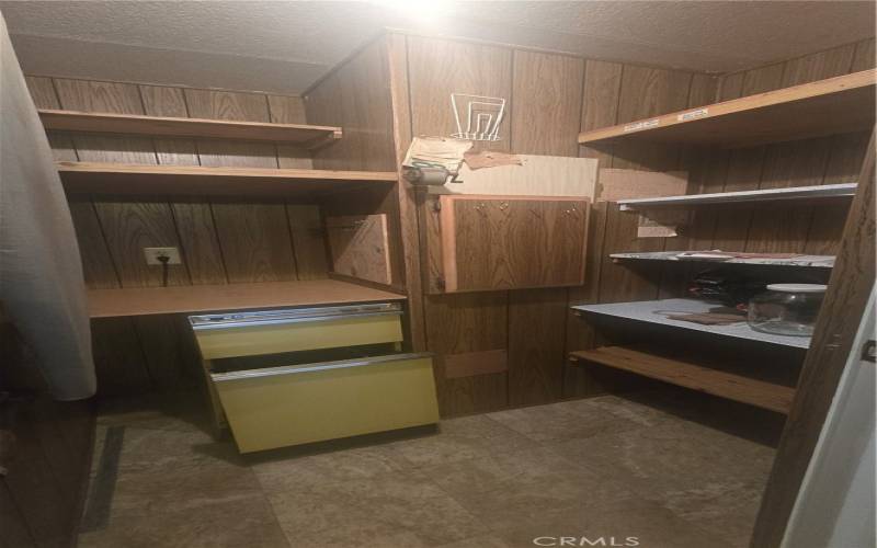 Walk-in kitchen pantry with trash compactor