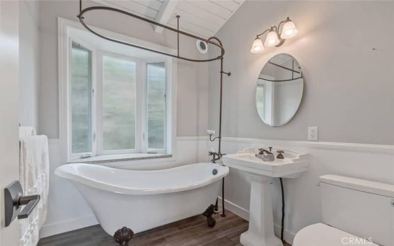 Remodeled bathroom complete with shower-over-tub and pedestal sink.