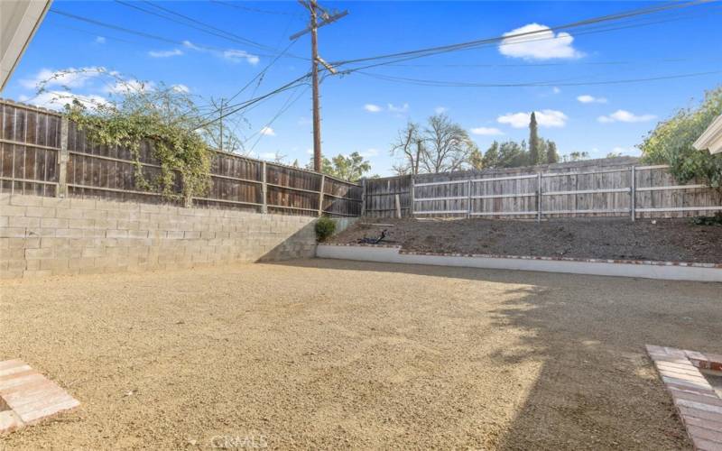 Looking across the large Back Yard with decomposed granite (DG) and brick-trimmed planters