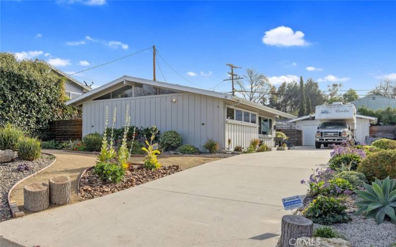 Long driveway with space for several vehicles, including RV access.