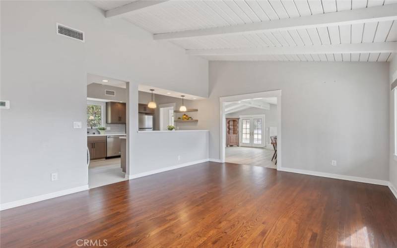 Just inside the front door is the Living Room with recently stripped and refinished wood floors. Beyond the doorways are the gorgeous, remodeled Kitchen and spacious, open beamed Family Room.