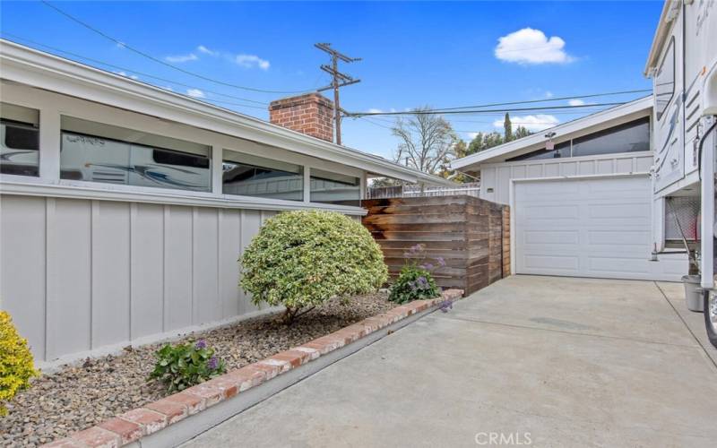 Long driveway with 2 car garage and fence that leads to Back Yard