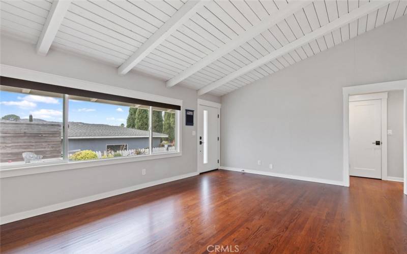 Living Room and Entrance with painted open beam cathedral ceilings, The arch on the right leads to the Bedrooms and Bathroom.