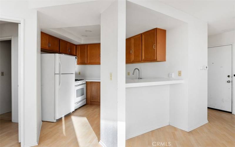 The kitchen includes a refrigerator and gas range.