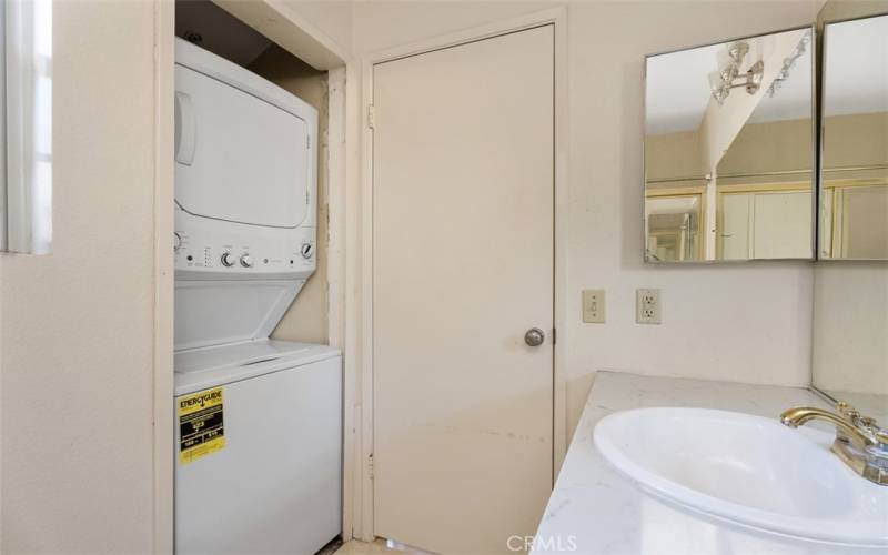 Stackable washer/dryer combo in secondary bathroom.