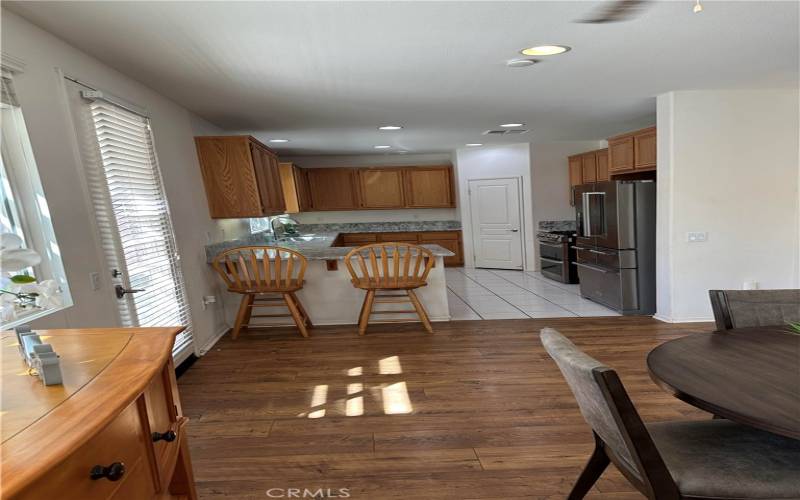 Dining room area next to the kitchen. Kitchen has quartz contertops, walk-in pantry, with new stainless steel appliances that are staying! Refrigerator, double ovens, microwave, and dishwasher. Recessed lighting and window above the sink.