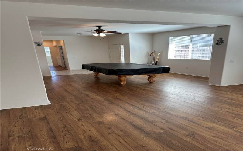 This photo allows you to see how nicely the wood laminate now flows from the family room with white tiled entry to the wood laminate hallway.