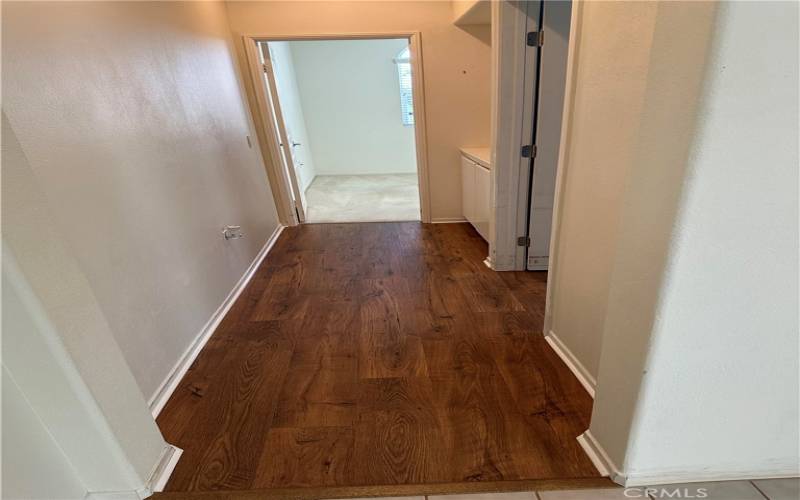 Hallway to the right of the front door is now water[roof wood laminate. This hallway leads to the second bathroom, hall cupboards, and the carpeted second bedroom that faces the golf course.