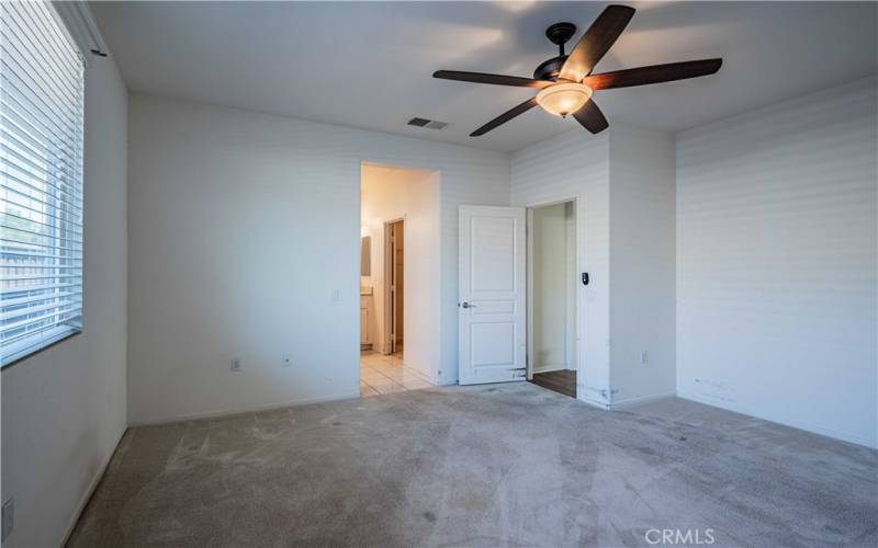 Primary bedroom is carpeted with ceiling fan and opens to your en-suite bathroom.