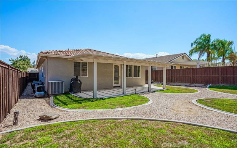 Back yard with patio and 5 grass areas. Brand new Air Conditioner unit.