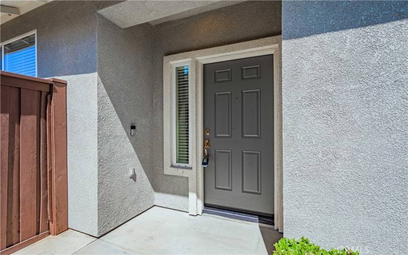 Front door has a window next to it, and the wood gate to the left opens to the back yard.