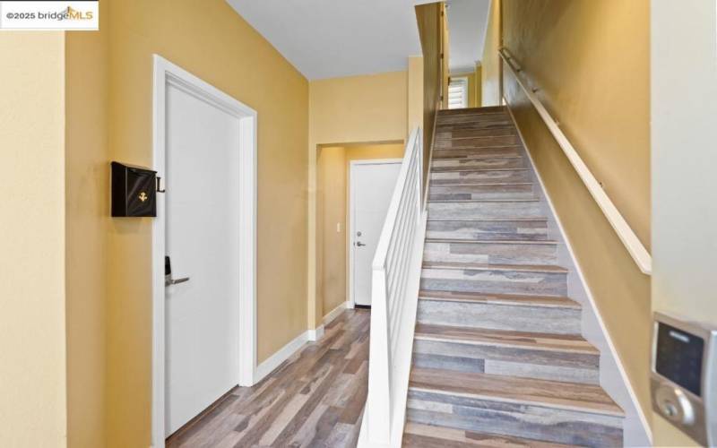 Entrance foyer.  Downstairs bedroom door and door to side by side garage in center.