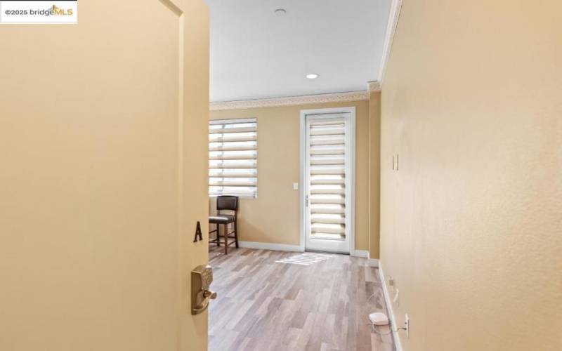 Main entry to second floor, view of living room and door to balcony.