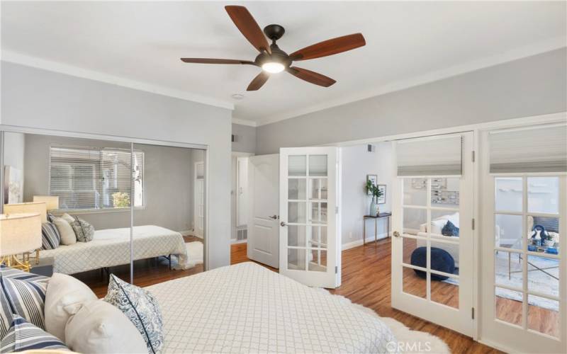 Secondary bedroom has double-wide mirrored wardrobes and beautiful french doors to living area.