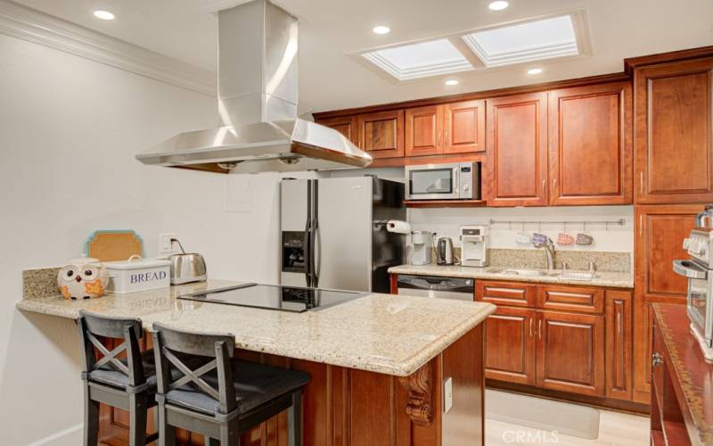 Beautifully remodeled kitchen with attractive wood cabinetry, granite countertops, stainless steel appliances and ample cabinet storage.