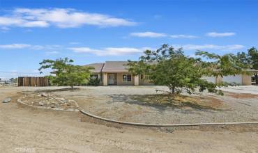 This is a beautiful single story home set back from the street with a long, wide driveway and some hardscape curbing in front.