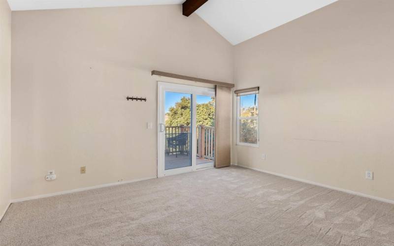 Primary suite with new carpet, where a vaulted ceiling and private deck offer moments of tranquility