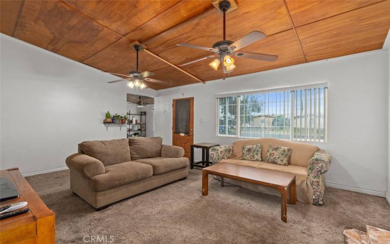 Living room with two ceiling fans and large window allowing natural light to flood the room