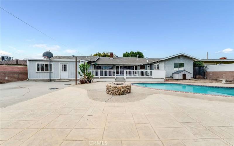 Back of house with sports court, firepit, covered patio and deck, and pool/spa