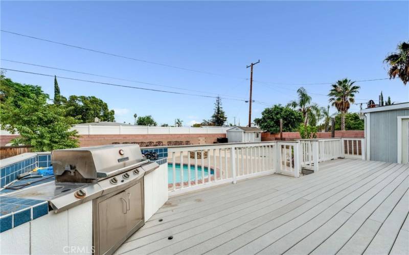 Outdoor BBQ and deck that overlooks the pool area