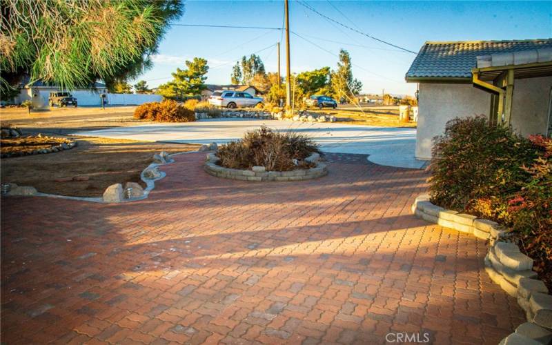 Brick paver entry and front patio with mature landscaping and pavers island.