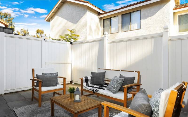 The patio area is fully enclosed by an upgraded vinyl fence, providing both  function and style to the outdoor space.