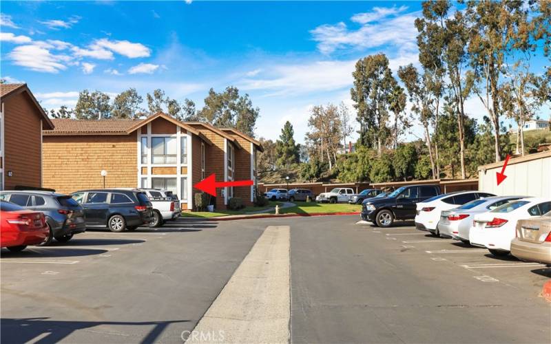 Parking for this unit (arrow on the right) is conveniently located across from the path that leads to the property (arrow on the left).