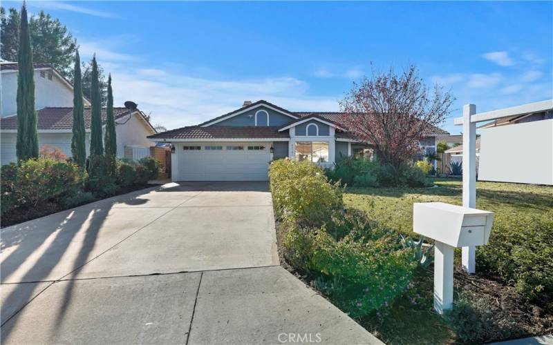 Two-car garage and a wide driveway with the landscaped front yard