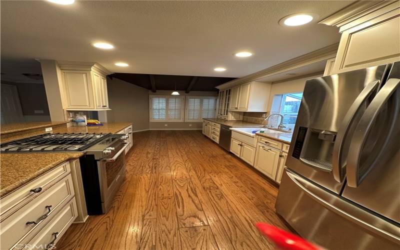 Galley style kitchen with nook and stainless steel appliances. Overlooks the living room.