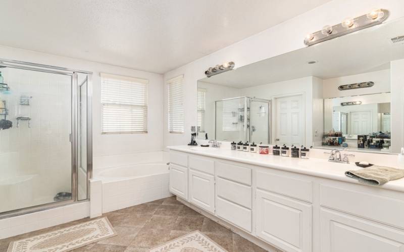 Primarly bathroom with dual sinks, Tub and shower