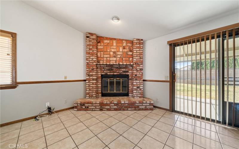 Den with inviting brick fireplace