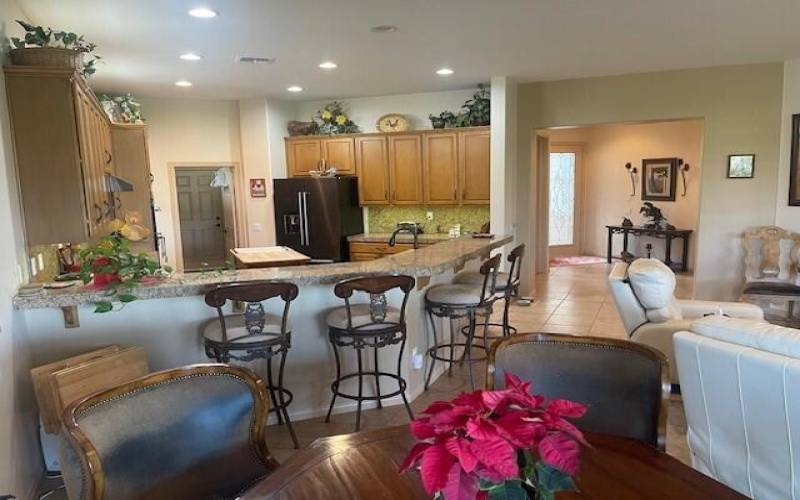 Wide angle of table, kitchen, entry and