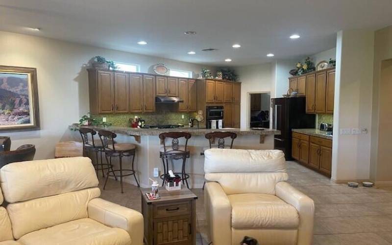 Wide angle of two chairs and kitchen