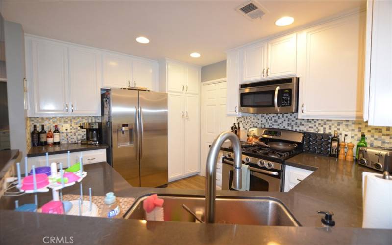 Remodeled kitchen with quartz counters, custom backsplash, newer sink/faucet, Stainless Samsung dishwasher, 5-burner stove and newer microwave.  Samsung refrigerator is also included.