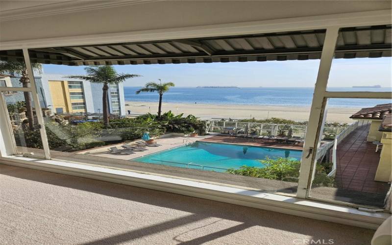 Living room overlooks pool and beach