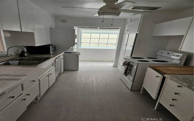 Galley kitchen with stacked laundry