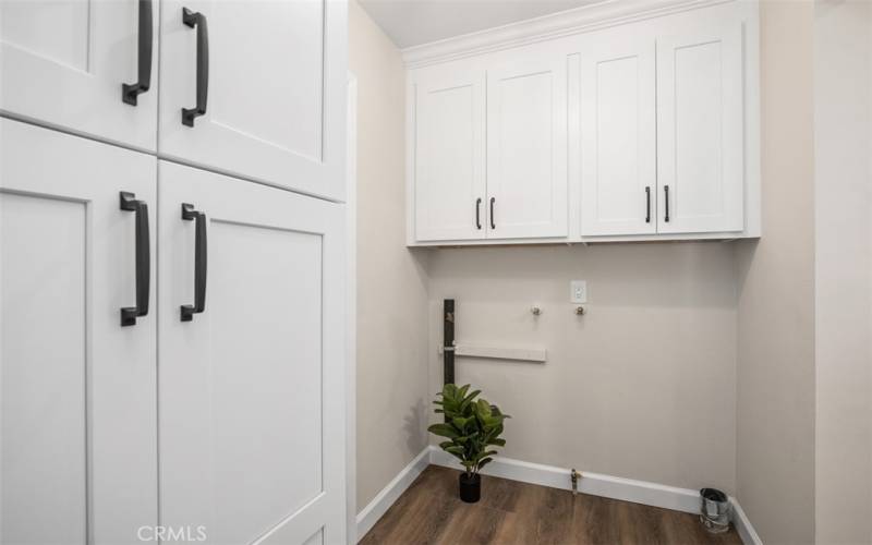 Laundry area off kitchen in hallway to bath with extra cabinets -