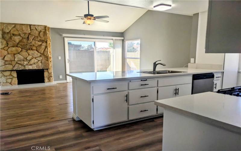 Kitchen Open to Family Room with Ceiling Fan and Fireplace