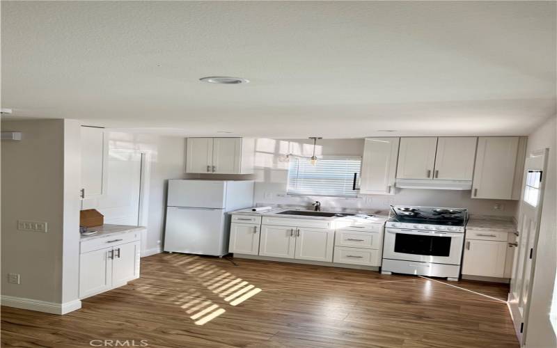 Open kitchen with new cabinets, countertops and appliances.