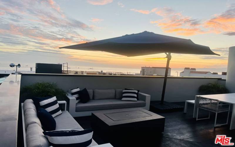 Rooftop deck w/dining table, seating area, fireplace and hot tub